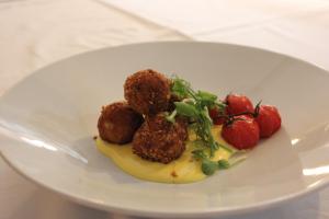 a plate of food with meatballs and strawberries on it at The Windmill Inn in Watchet
