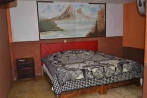 a bedroom with a bed with a painting on the wall at H MEXICANA DE MÁRMOL in Tehuacán