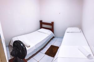 Habitación con 2 camas y ventilador en el suelo en Apartamento Vila Isabel, en Maragogi