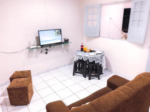 sala de estar con sofá y mesa en Apartamento Vila Isabel, en Maragogi