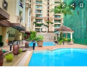 un hotel con piscina frente a un edificio en Kenyalang Emerald Riverine Resort Homestay, en Kuching