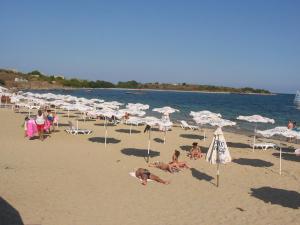 a group of people on a beach with umbrellas at Apartment on the sea at St Nikolas Complex-Ekaterina in Chernomorets