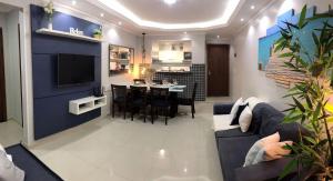 a living room with a couch and a dining room at Apartamento com Clube e Vista para o Lago in Cabo Frio