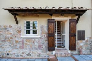 una entrada a un edificio de piedra con puertas de madera en Col di Pietra en Montaione