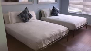 a room with two beds with white sheets and pillows at 918 SOBE FLATS in Miami Beach