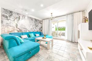 sala de estar con sofá azul y mesa en Luxury Townhouse Oasis Fanabe (3 bedrooms), en Adeje