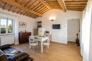 Una cocina y una sala de estar con mesa y sillas. en Col di Pietra, en Montaione
