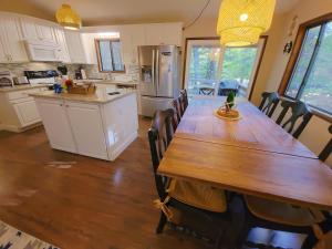 a kitchen with a long wooden table and chairs at Indoor Pool, Firepit, Self Check-in, BBQ, FREE Amenities, KING Bed, Full Kitchen in Lake Ariel