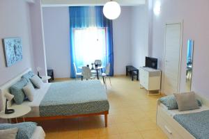 a room with two beds and a couch and a television at B&B Lecce Stazione Centrale in Lecce