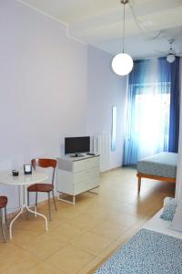 a living room with a desk and a bed and a table at Lecce Stazione Centrale in Lecce