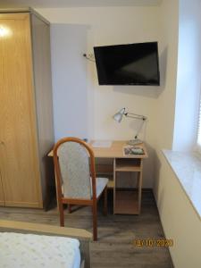 Zimmer mit einem Schreibtisch mit Stuhl und einem TV in der Unterkunft Gästezimmer 1 mit Bad in Angersbach