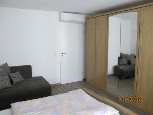 a living room with a couch and a mirror at Gästezimmer 1 mit Bad in Angersbach +4 photos