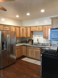 cocina con armarios de madera y nevera de acero inoxidable en 8th South Apartments, en Salt Lake City