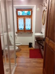 a bathroom with a toilet and a sink and a window at tana del paradiso due in Baceno
