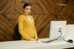 una mujer parada frente a un escritorio con un ordenador en Hotel People, en Cheboksary