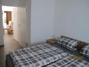 a bedroom with a bed and a table and a door at Ruhiges Zimmer 2 in Angersbach