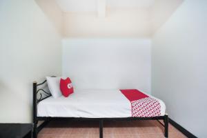 A bed or beds in a room at OYO 963 Sunshine Guesthouse