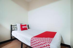 A bed or beds in a room at OYO 963 Sunshine Guesthouse