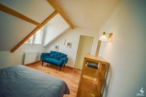 - une chambre avec un lit bleu et une chaise bleue dans l'établissement Maison PISCINE INTERIEURE et GARAGE, à Troyes