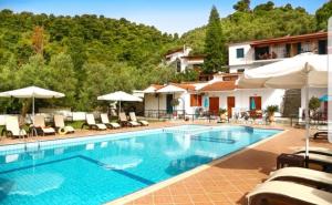 a swimming pool with chairs and umbrellas at a hotel at Villa Anni in Skiathos Town