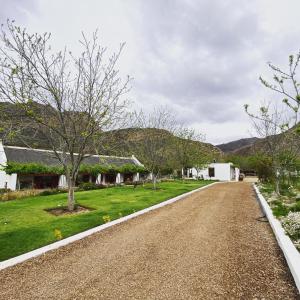 a gravel road in front of a house at Alpaca Inn in Montagu