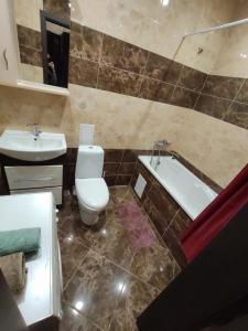 La salle de bains est pourvue de toilettes, d'un lavabo et d'une baignoire. dans l'établissement Daily rent Apartments 5, à Ivano-Frankivsk