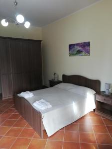 een slaapkamer met een groot bed met witte lakens bij Le Coste Affittacamere in San Lupo