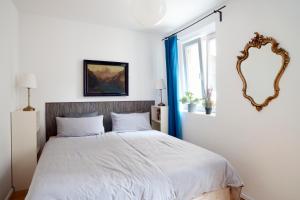 a bedroom with a large bed and a mirror at Beautiful Park Apartment for 4 Guests in Berlin