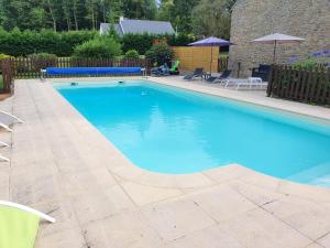 a large swimming pool with blue water in a yard at LA ROCQUE in Bonnemain