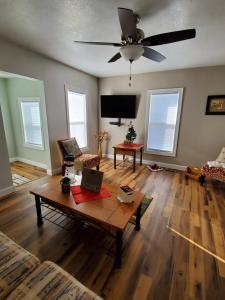 a living room with a table and a ceiling fan at THE LOST GEM.... A Little Bit Country in Oskaloosa