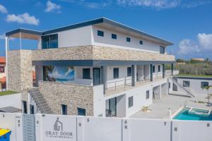 une villa avec une piscine et un bâtiment dans l'établissement Gray Door Apartments - Adults only, à Palm-Eagle Beach