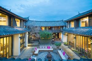 an exterior view of a building with a courtyard at 丽江无尔雪山下泳池花园民宿 in Lijiang