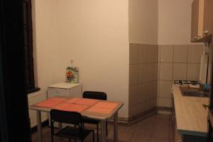 cocina con mesa, sillas y fregadero en Downtown central-apartment, en Oradea