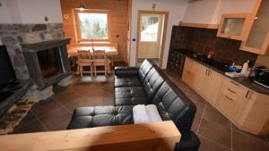 een woonkamer met een bank en een open haard bij Chalet Corone Monte Zoncolan in Sùtrio