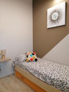 una piccola camera con letto e una foto appesa al muro di La Casa delle Rondini a Montelupo Fiorentino