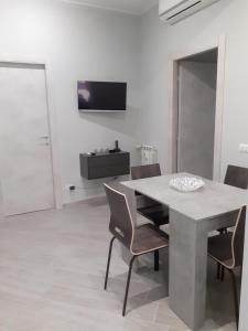 ein weißes Esszimmer mit einem Tisch und Stühlen in der Unterkunft IL QUADRIFOGLIO in Rom