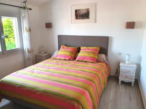 フロンティニャンにあるVilla Doraのベッドルーム1室(大型ベッド1台、カラフルなストライプ毛布付)