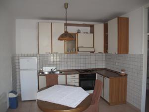 a kitchen with white appliances and a table in it at Apartments Žuvela in Korčula
