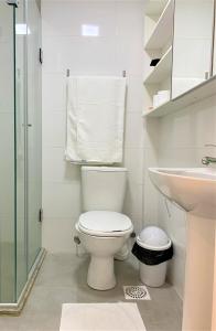 a white bathroom with a toilet and a sink at Apartamento impecável FM - RETIRADA DAS CHAVES MEDIANTE AGENDAMENTO COM UMA HORA DE ANTECEDÊNCIA COM ANDREIA OU LUIS in Porto Alegre