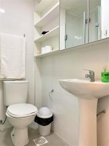 a white bathroom with a toilet and a sink at Apartamento impecável FM - RETIRADA DAS CHAVES MEDIANTE AGENDAMENTO COM UMA HORA DE ANTECEDÊNCIA COM ANDREIA OU LUIS in Porto Alegre