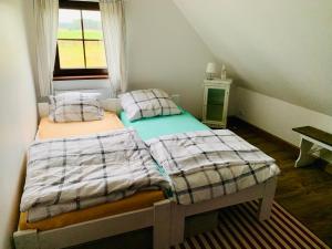 two twin beds in a small room with a window at Domek całoroczny na Kaszubach "Kołowrót" in Dziemiany