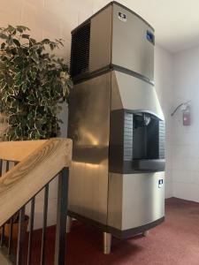 a stainless steel refrigerator sitting next to a plant at Bancroft Inn & Suites in Bancroft