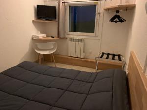 a small room with a bed and a window at Hotel Macon la Salle in Mâcon