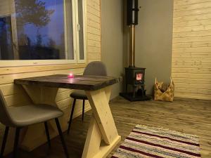 a table with a candle on it in a room with a stove at Aurora Husky Hut in Inari
