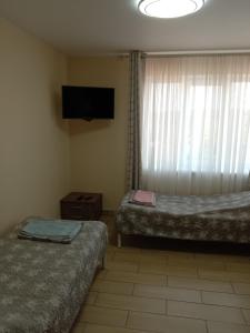 a room with two beds and a flat screen tv at 105 in Khmelnytskyi