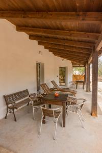 a patio with a table and chairs and a wooden ceiling at Cottage a 5 minuti dal mare in Nardò