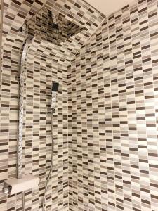 eine Dusche im Bad mit einer gefliesten Wand in der Unterkunft Gîte de Beg Menez Le 26 - Gîte à La Forêt-Fouesnant in La Forêt-Fouesnant + 17 Fotos