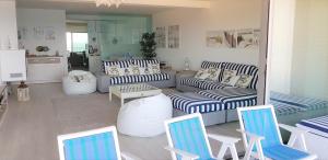 a living room with couches and chairs and a kitchen at Avenida dos Banhos Apartment in Póvoa de Varzim