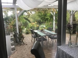 eine Terrasse mit einem Tisch und Stühlen sowie einem Garten in der Unterkunft Bokelrehm in Bokelrehm