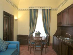 ein Wohnzimmer mit einem Tisch und einem blauen Sofa in der Unterkunft Hotel La Ville in Catania